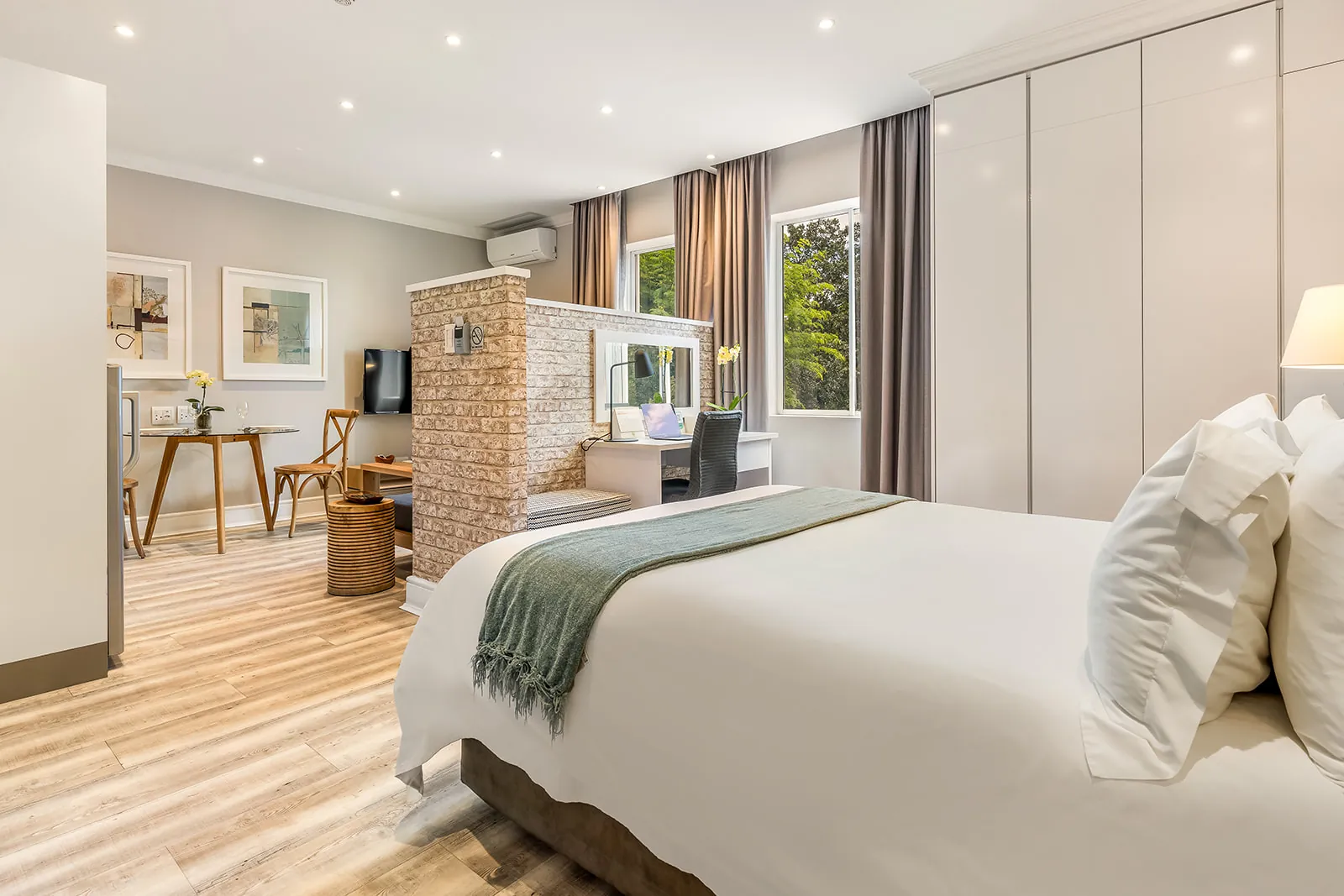 Studio suite with exposed-brick partition separating the bed and workspace | Studio Stay on Sixty6 boutique hotel & accommodation in Sandton